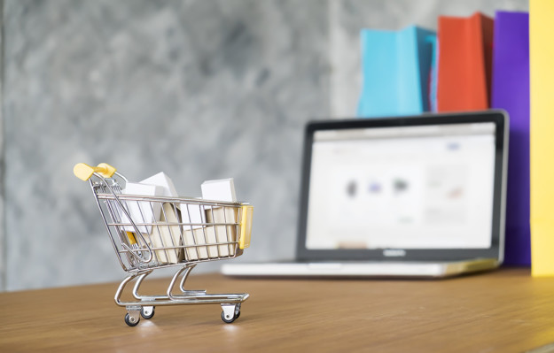 Business theme, internet online shopping concept, shopping delivery, shopping cart carry shopping mail box and blur background of shopping bag and open laptop